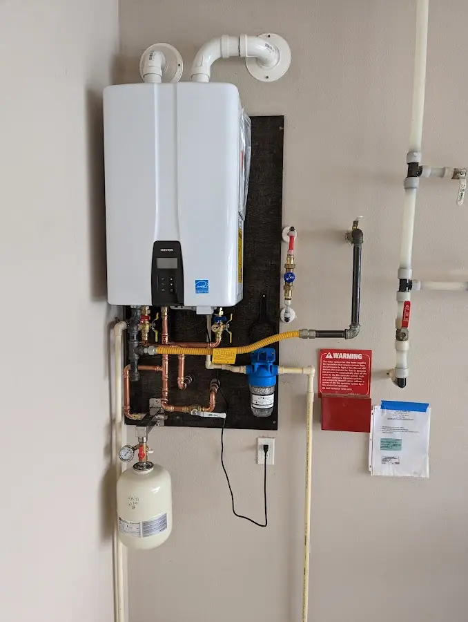 Professional plumber installing copper piping in a Denair home